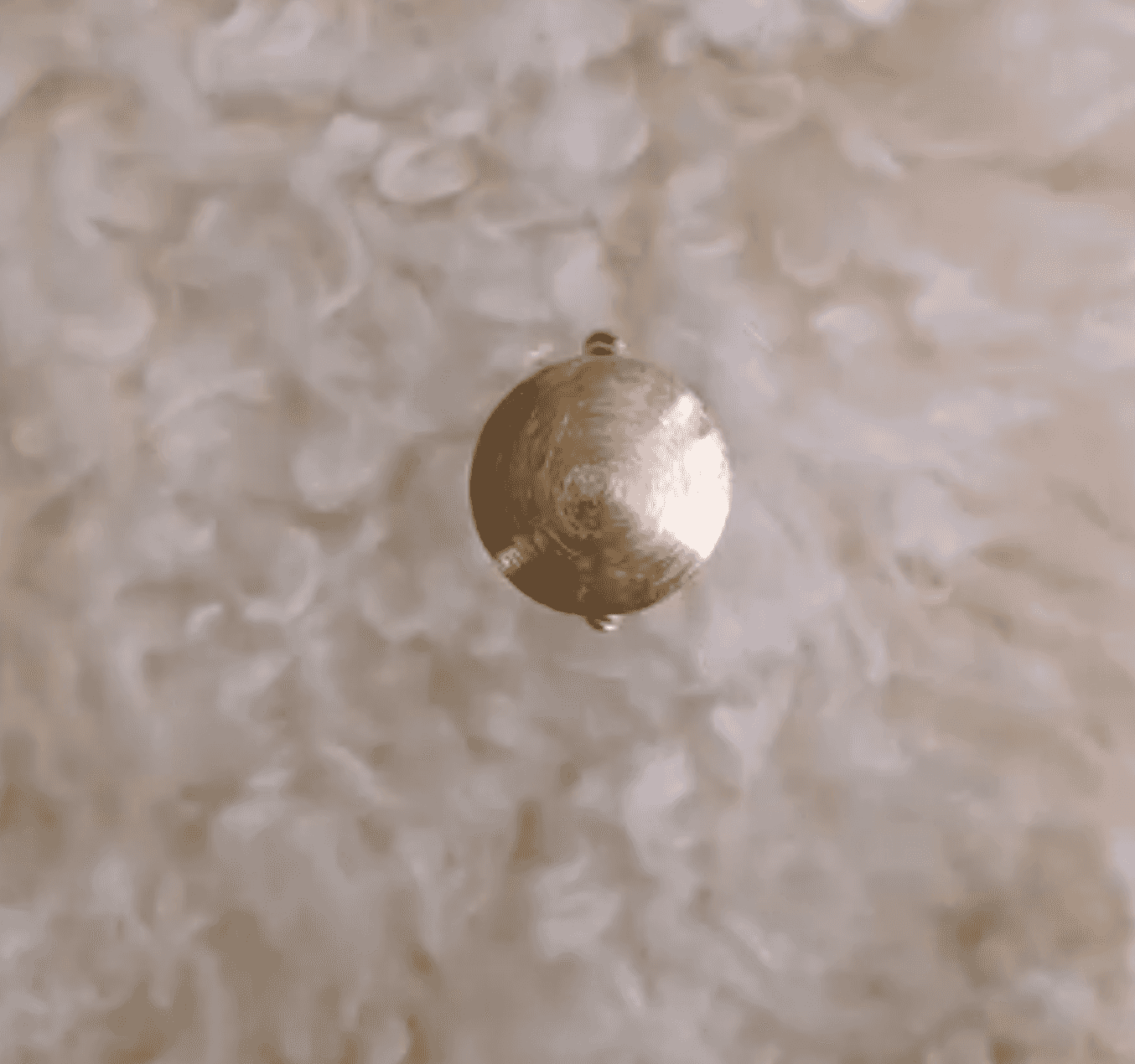 Gold filigree pendant catching morning light