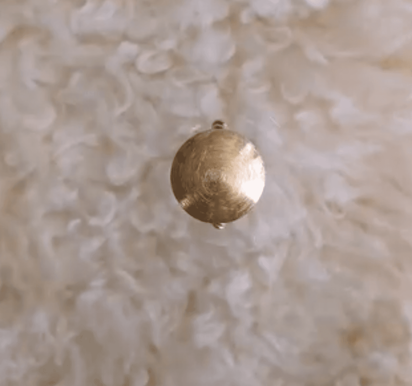 Gold filigree pendant catching morning light