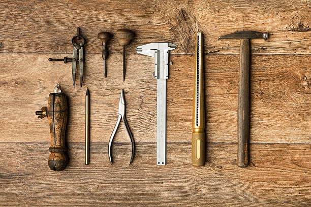 Traditional goldsmith tools on leather-topped workbench